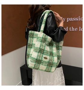 Detail of green and white checkerboard plush tote bag with thick wool texture and logo tag