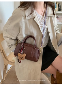 Minimalistische dunkelbraune Retro-Bowlingtasche mit Plüschbärenanhänger und Gurt