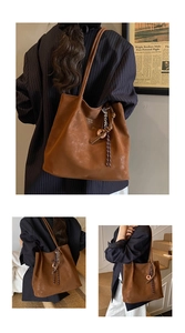 Close-up of brown suede tote bag featuring braided tassel charm and matte leather texture
