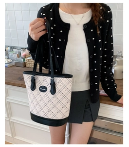 Close-up of retro cream tote bag featuring black polka dots and mesh pattern details