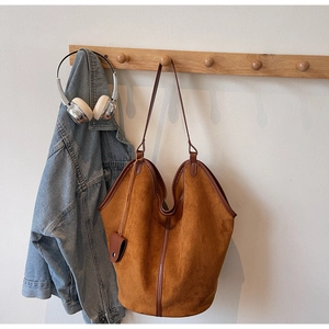 Brown vintage hobo tote bag hanging with denim jacket and headphones for daily use