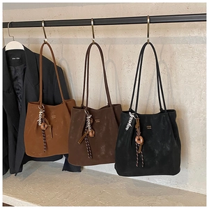 Detailed display of three soft suede tote bags with artistic pendants and COIN 2DN logos