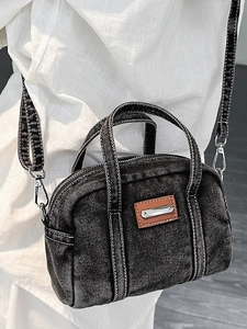 Distressed dark denim tote bag with contrast stitching and adjustable crossbody strap