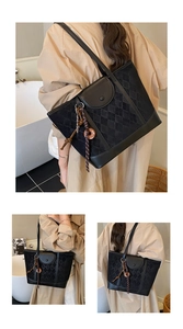 Detail view of black quilted tote bag featuring leather stitching and side tassel accents