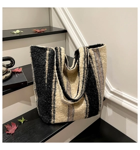 Close-up of a striped fleece tote bag with a handmade logo tag and fuzzy texture