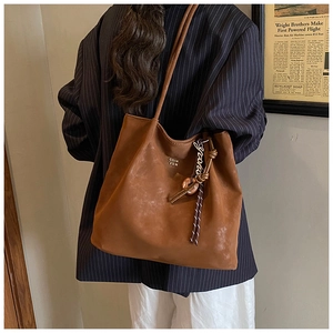 Detailed side view of a large vintage brown tote bag showing its soft leather texture and charm