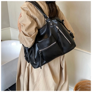 Detail of high-capacity black PU leather tote bag with functional exterior zippers