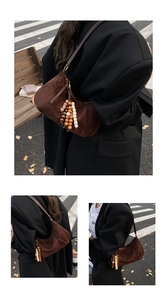 Dettaglio di una borsa a spalla in pelle scamosciata marrone con nappa di perline di legno