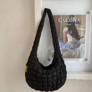 Detail of black quilted cloud bag texture and a yellow fashion tag on the side