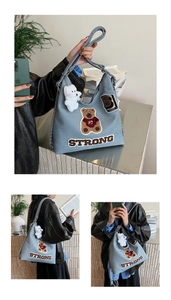 Dettaglio della borsa tote in denim azzurro con patch orsetto e ricamo STRONG