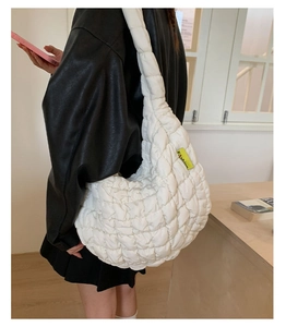 Close-up of white quilted cloud bag with Fashion label and fluffy nylon texture