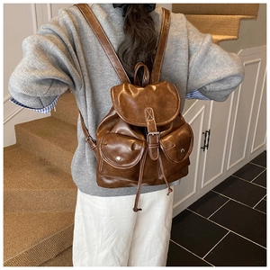 Vue détaillée d'un sac à dos marron en similicuir avec cordon et boucles métalliques
