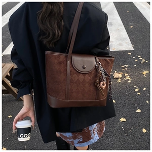 Detailed view of dark brown tote bag with suede texture and embossed diamond patterns