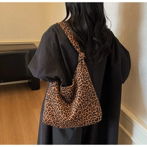 Detail of hobo shoulder bag featuring leopard print fabric and a knotted strap design