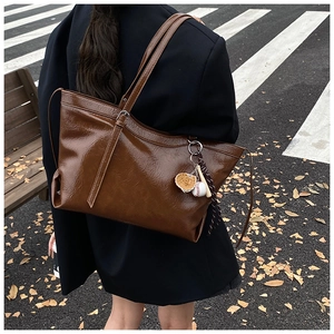 Grand sac cabas marron foncé en cuir froissé brillant avec un pendentif baseball