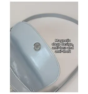 Close-up of a light blue handbag featuring a secure magnetic snap closure for anti-theft