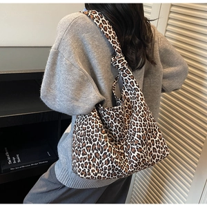 Detail showing high-capacity leopard print canvas tote bag with unique knot handle design