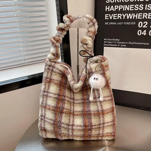 Close-up of vintage plaid fleece tote bag with ruched handle and plush doll pendant