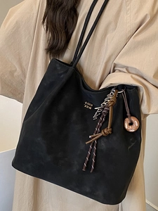 Chic black faux suede large tote bag with gold lettering and decorative charms