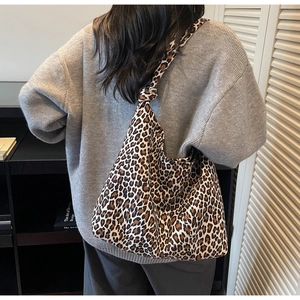 Detail of leopard print canvas bag featuring a unique knot-style shoulder strap design