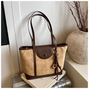 Detail of vintage tote bag featuring khaki diamond patterns and brown leather trims