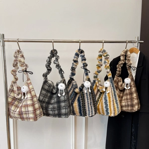 Detail shot of vintage plush tote bags with plaid patterns and cute monster charms