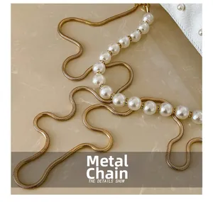 Detail of luxury pearl handle with gold hardware chain and white silk texture