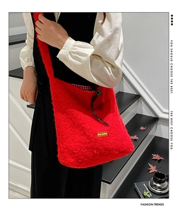 Detail of red faux fur bucket bag featuring a classic red and white plaid inner lining