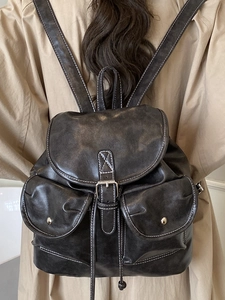 Sac à dos vintage marron foncé avec coutures blanches et rivets métalliques