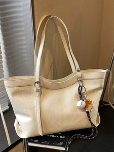 Grand sac cabas beige en similicuir texturé avec pendentif de baseball et fines anses