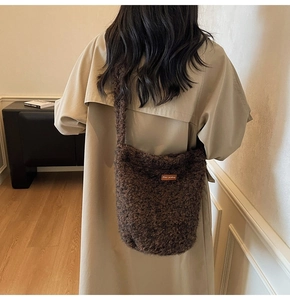Detailopname van de pluizige bruine pluche bucket bag met leren Star-picking label