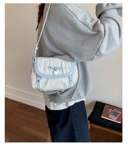 Blue bow pattern shoulder bag shown on model for size and outfit perspective