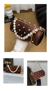 Detail of a brown cylindrical pearl handbag with golden chain strap and velvet finish