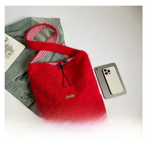 Detalle de bolso de pelo sintético rojo con etiqueta de cuero y forro de cuadros