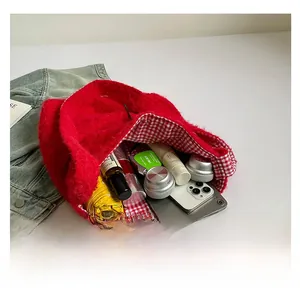 Vista interna del bolso tote de felpa roja que muestra gran capacidad para esenciales