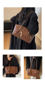 Detail of brown woven tote bag showing texture, brand logo, and beaded tassel charm