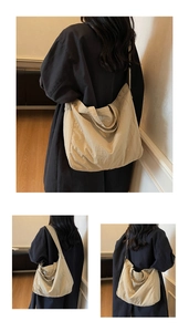 Detail of a beige canvas tote bag with long shoulder straps and reinforced handles