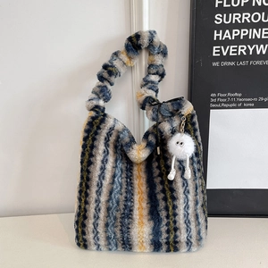 Detail of plush multi-color striped tote bag with soft faux fur texture and eye charm