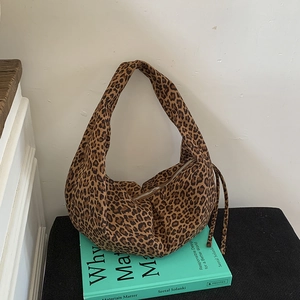 Détail du sac hobo en toile léopard avec fermeture éclair et sangles décoratives