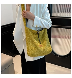 Detalle de bolso bandolera amarillo de felpa con textura de lana y etiqueta roja