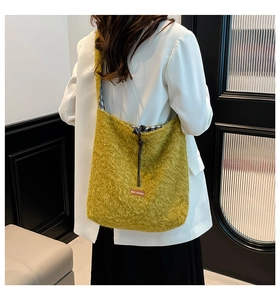 Detail of mustard yellow plush shoulder bag with plaid lining and drawstring closure
