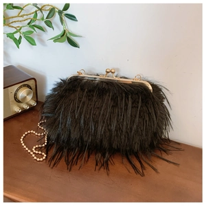 Detail of black faux fur clutch bag featuring gold ball clasp and vintage bead chain