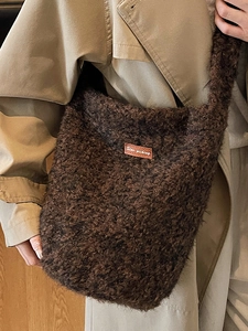 Retro pluchen emmertas in donkerbruin met leren patch gedragen door model in trenchcoat