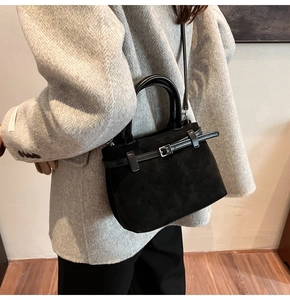 Detail of black frosted suede tote bag with leather straps and silver buckle detail