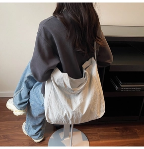 Detail of the large capacity tote bag featuring dual handles and textured fabric finish