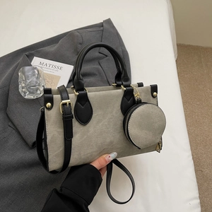 Détail d'un sac cabas en toile contrastée avec bordure en cuir et porte-monnaie rond