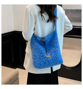 Detail of blue plush hobo bag showing soft faux fur texture and drawstring closure