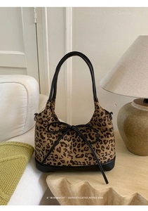 Detail of retro leopard print tote bag with black leather trim and bow tie decoration