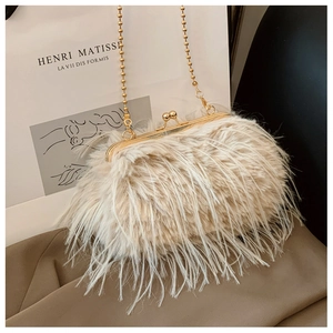 Close-up of beige faux fur handbag featuring golden ball clasp and metallic chain strap
