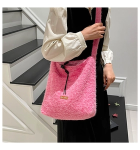 Primer plano de bolso rosa de piel sintética con etiqueta de cuero y forro a cuadros